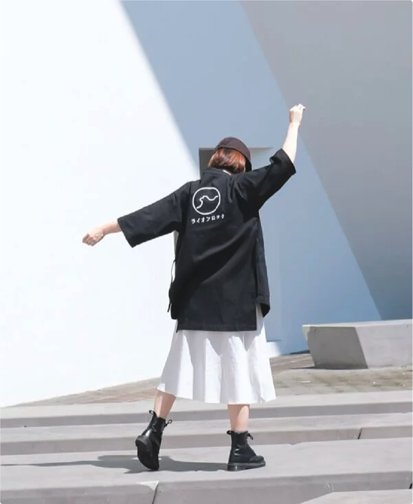 Female model posing outdoors in black Kamon Kimono Jacket-Lion Rock at Grandmama Store in Hong Kong
