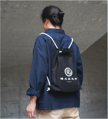 Light of Dawn Sake Bag Black Denim drawstring backpack model lookbook photo at Grandmama Store in Hong Kong.
