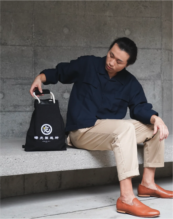 Light of Dawn Sake Bag Black Denim seated lifestyle photo at Grandmama Store in Hong Kong.