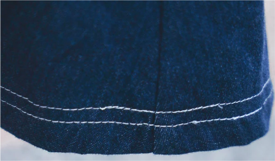 Macro detail of Kamon Denim Dress double-stitched hem at Grandmama Store in Hong Kong