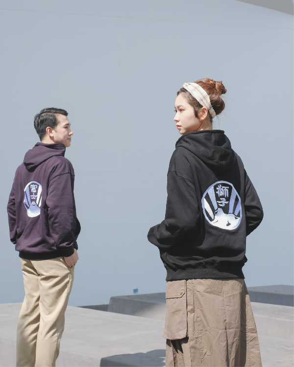 Male and female models showcasing back designs of the Kamon Hoodie collection at Grandmama Store in Hong Kong.