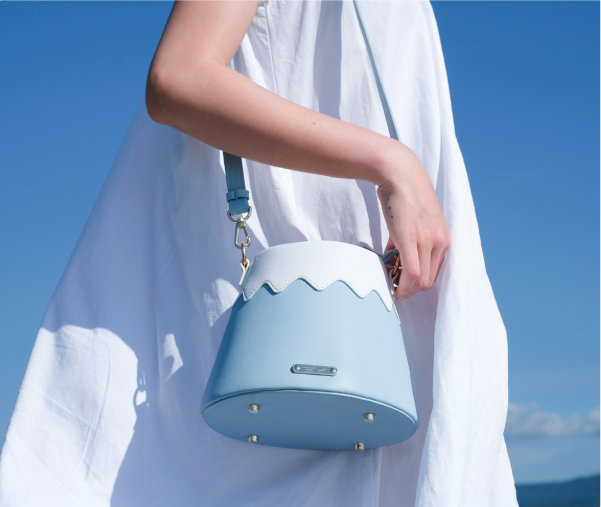 Model holding the light blue Mt. Fuji Goen Bag against the blue sky at Grandmama Store in Hong Kong