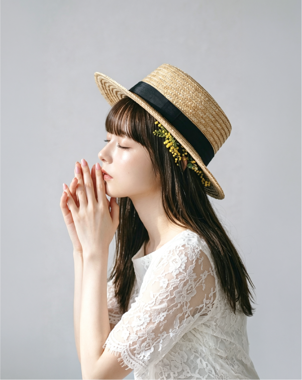Profile view of model in white lace wearing French Straw Boater Hat with flower detail at Grandmama Store in Hong Kong