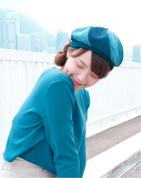 Side view of model posing in dual-tone teal Sunshine Beret at Grandmama Store in Hong Kong