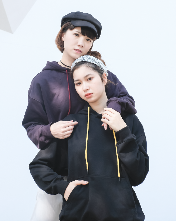Two models posing in dark purple and black Kamon Hoodies with contrast drawstrings at Grandmama Store in Hong Kong.