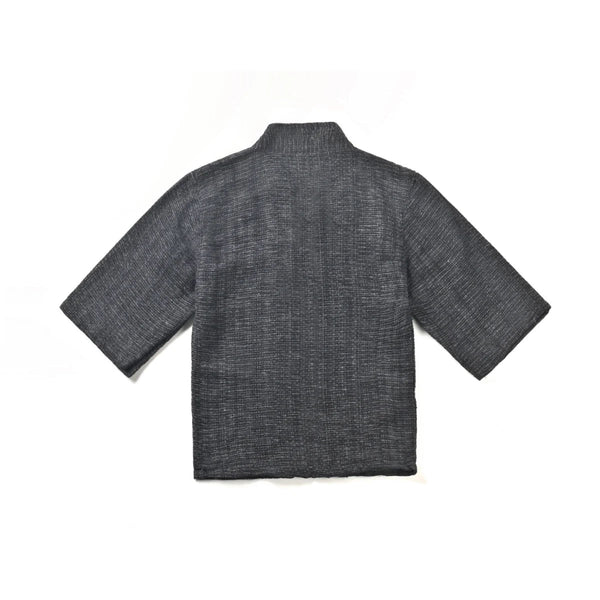 The back view of a hand-cranked Kimono jacket in Miho Matsubara color showing the textured charcoal gray handwoven fabric at Grandmama Store in Hong Kong.